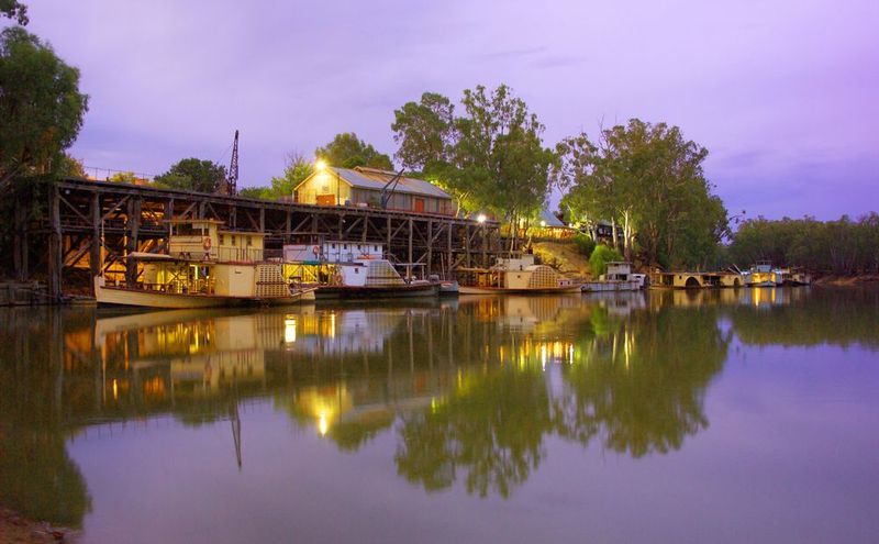 A Bridge Over a River With Boats Docked in the Water at Night — Shepparton Radiators & Windscreens in Echuca, VIC