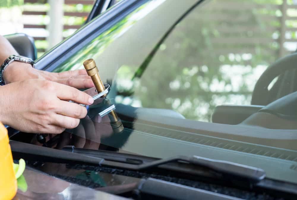 A Person is Fixing a Broken Windshield on a Car — Shepparton Radiators & Windscreens in Yarrawonga, VIC