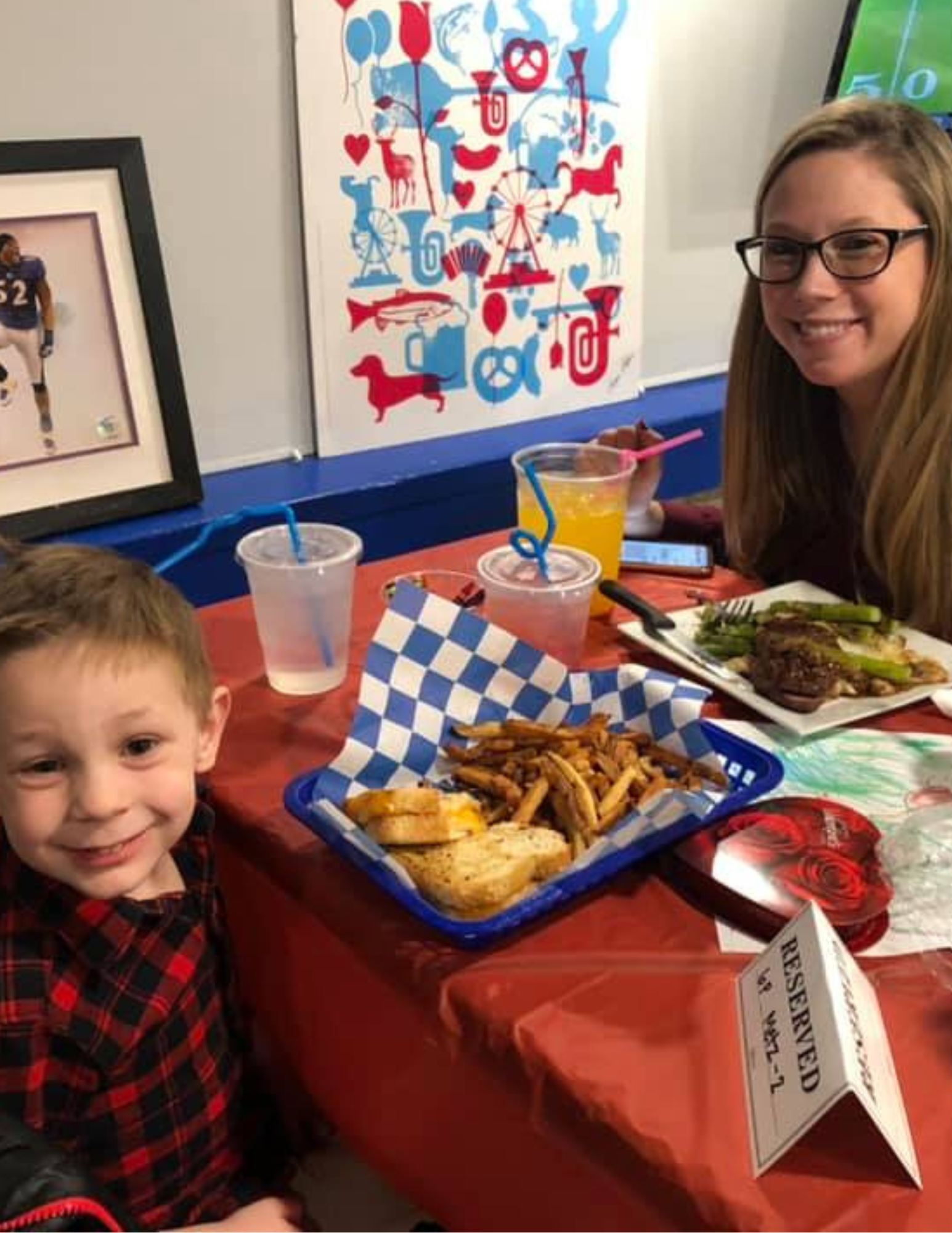 Mom and a child are sitting and eating at a restaurant table