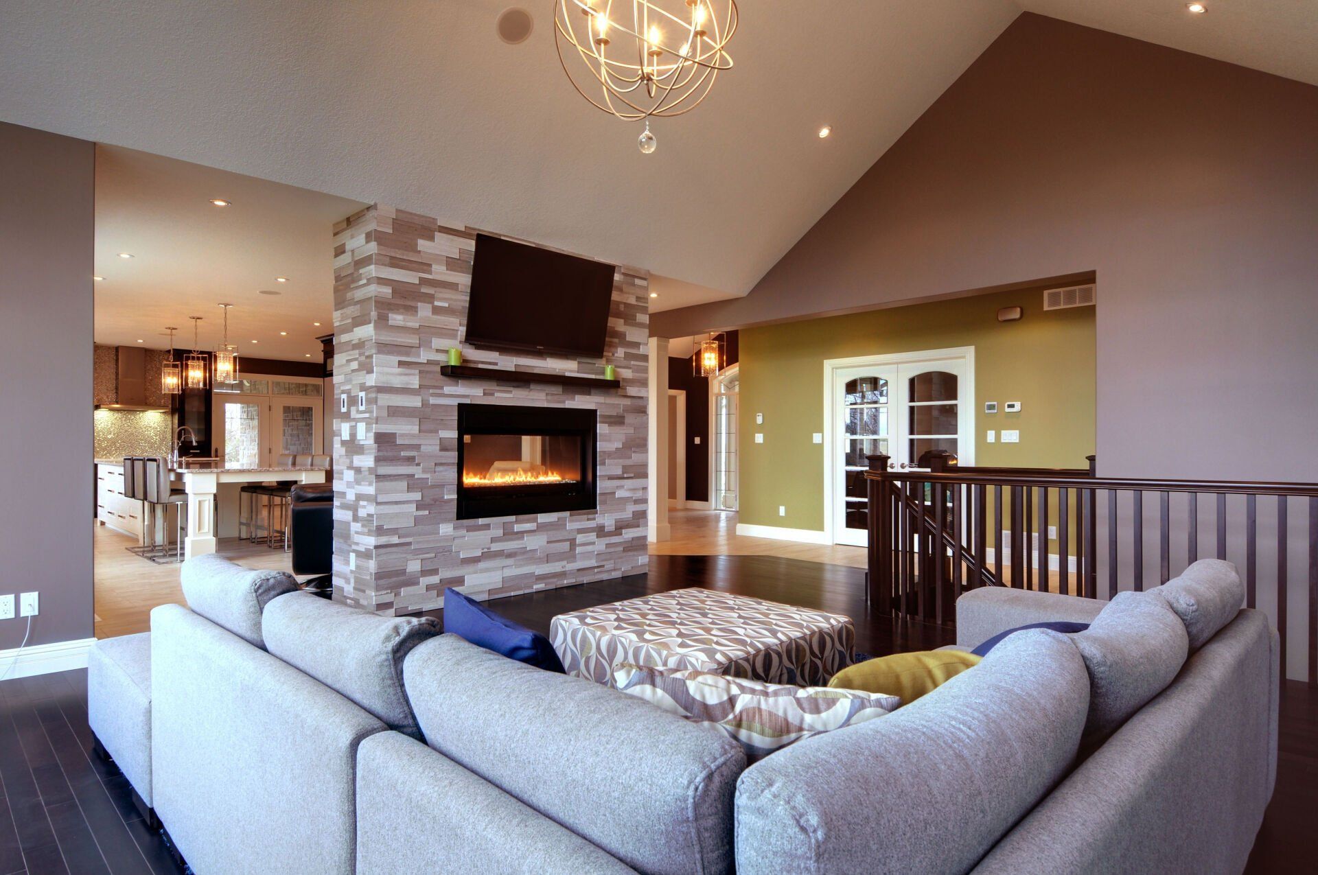 A living room with a large sectional couch and a fireplace