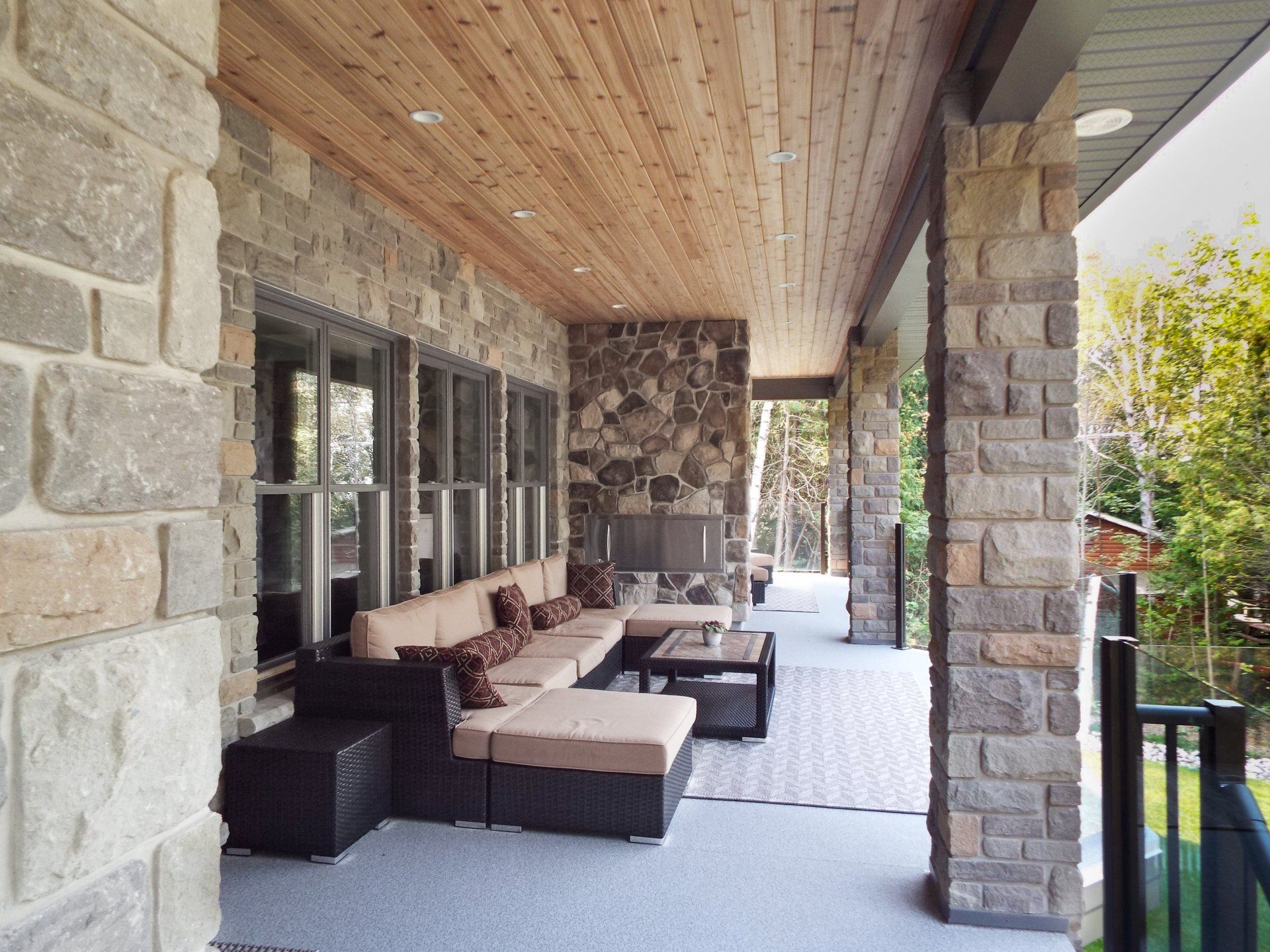 A porch with a lot of furniture and a wooden ceiling