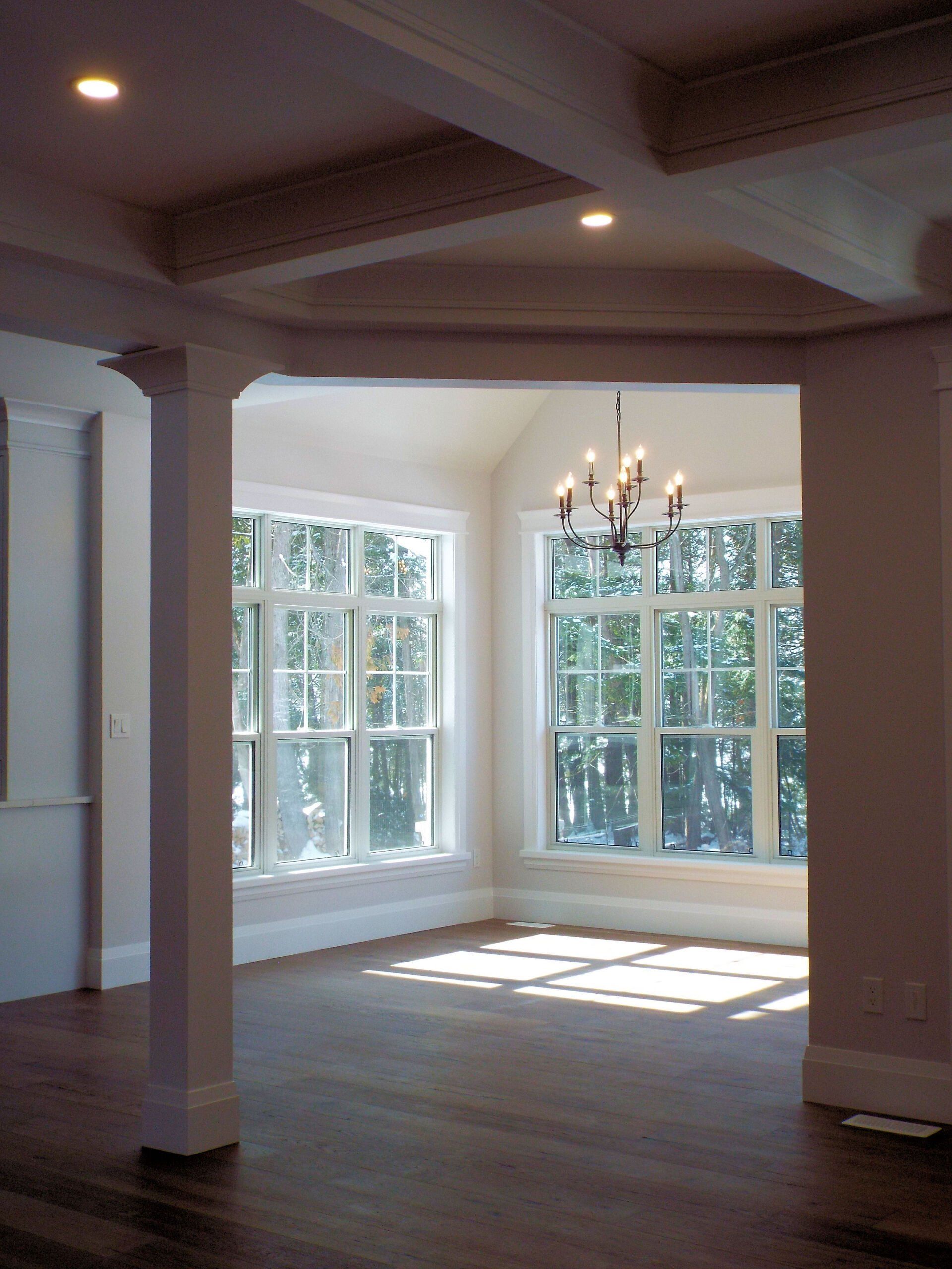 An empty room with lots of windows and a chandelier