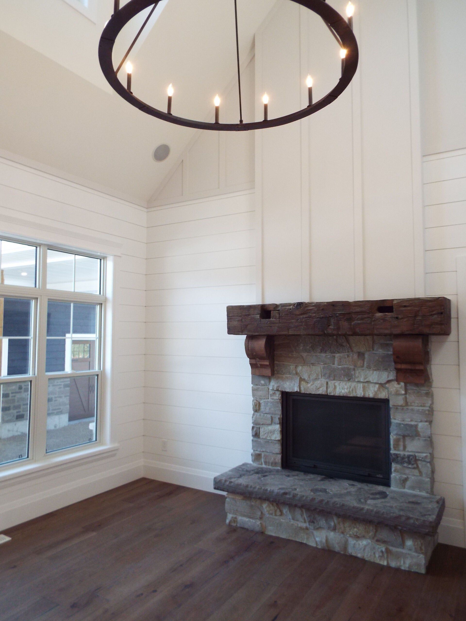 A living room with a fireplace and a chandelier hanging from the ceiling