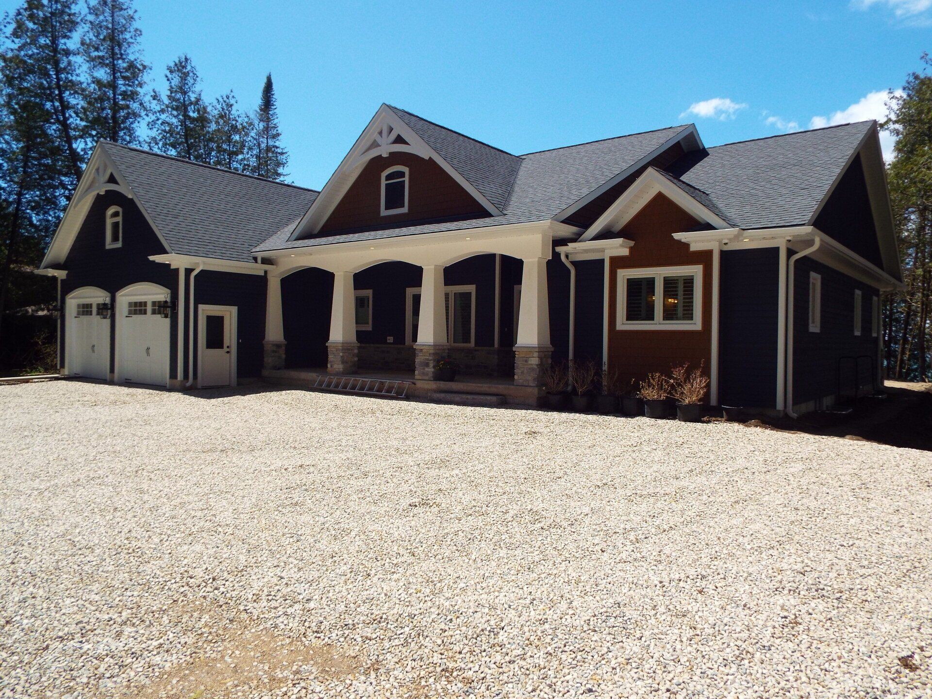 A large house with a gravel driveway in front of it