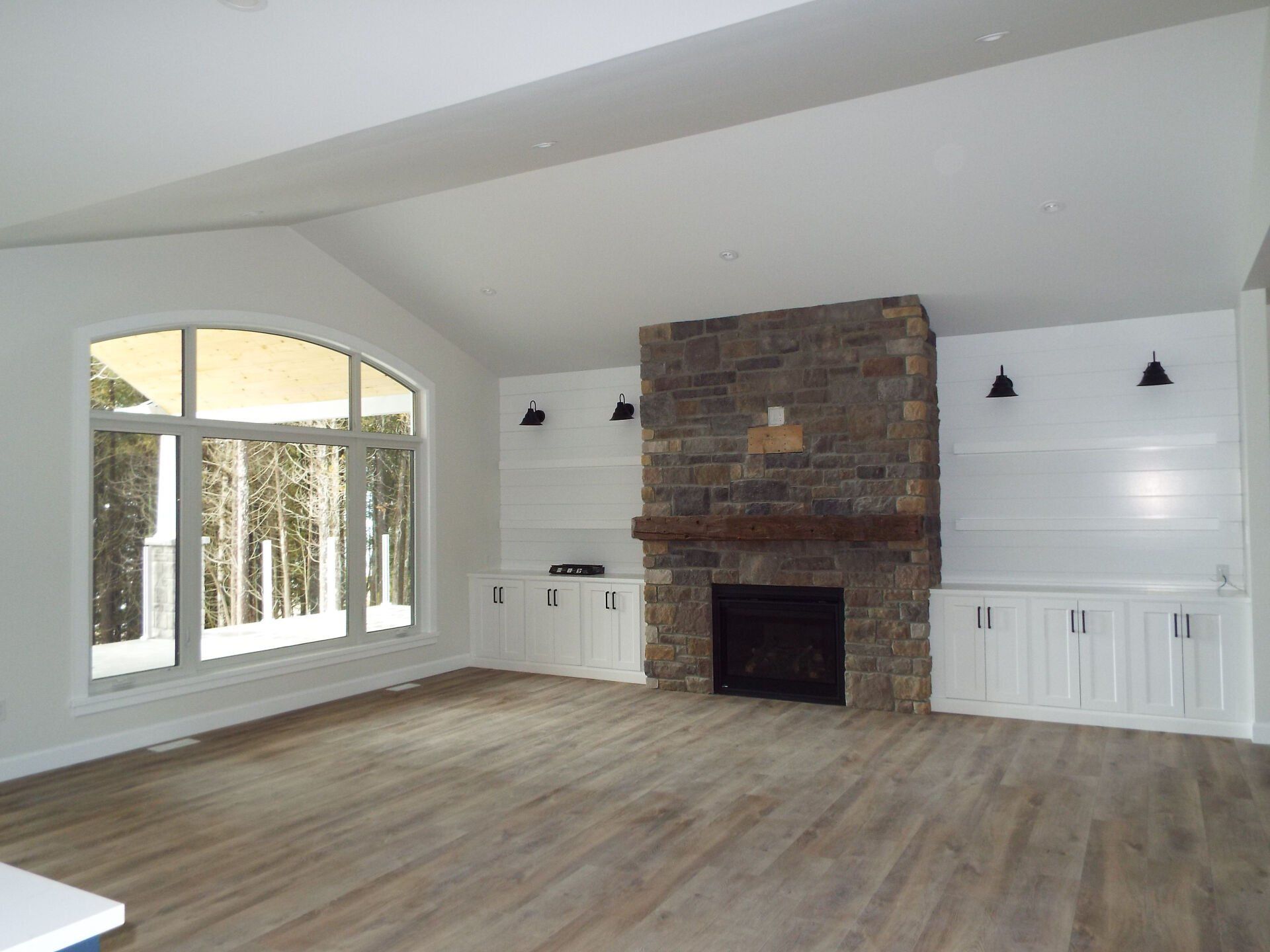 A living room with a fireplace and lots of windows