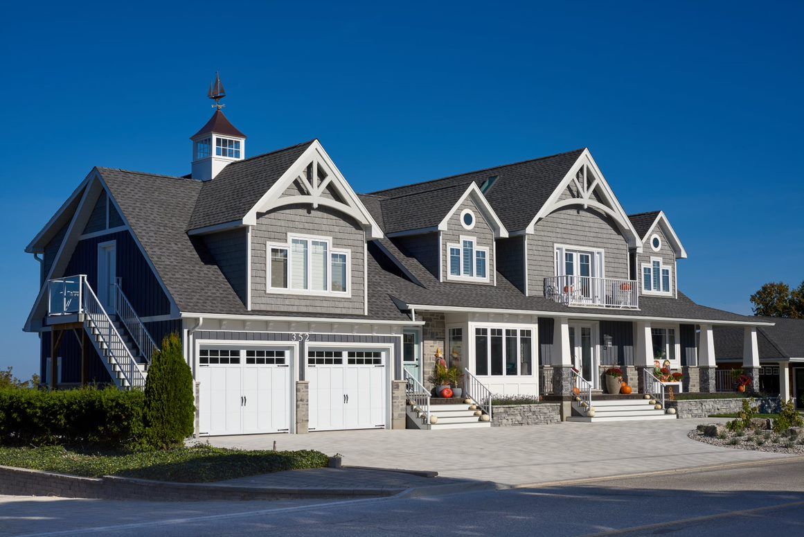 A large house with a gray roof and white trim