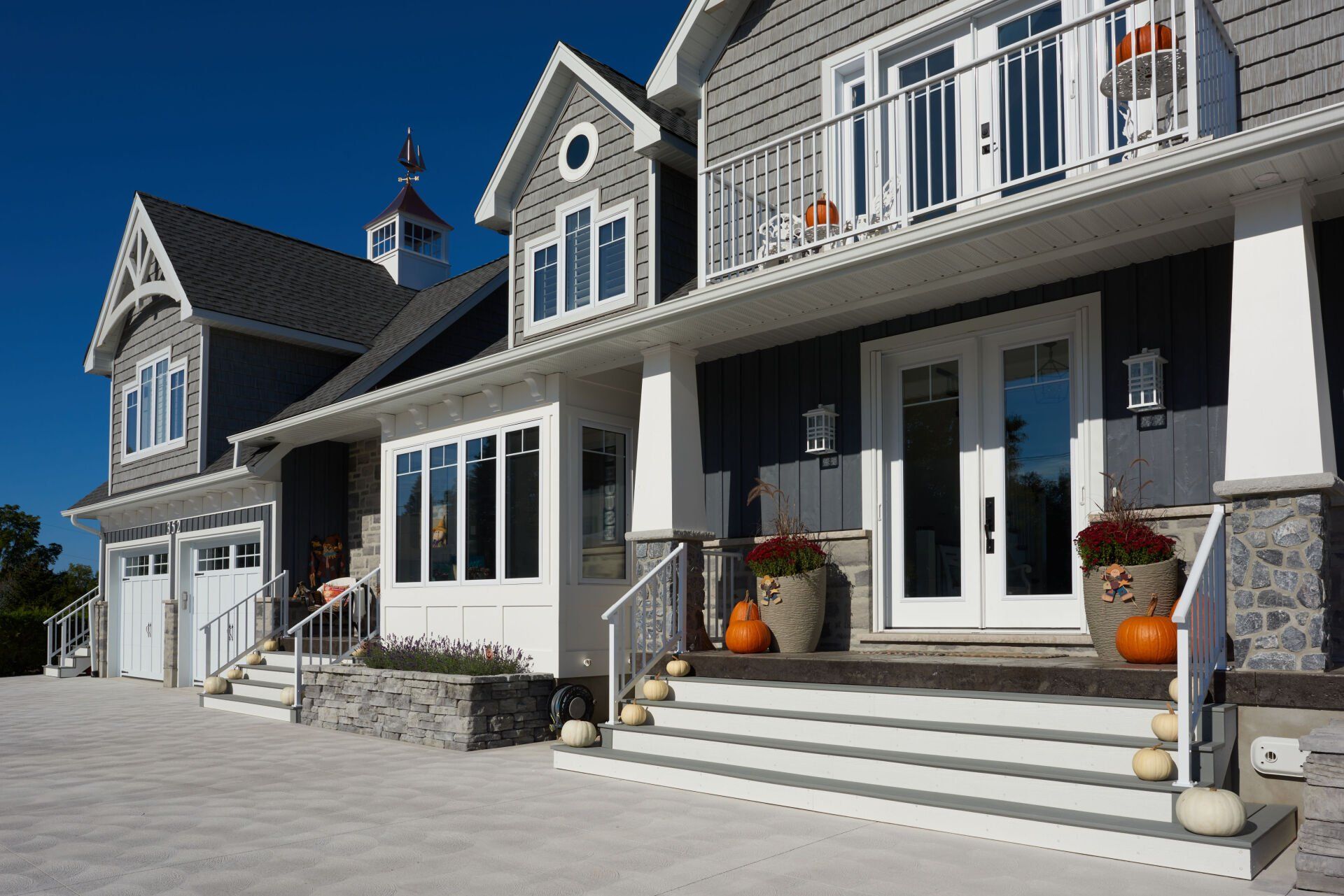 A large house with pumpkins on the porch and stairs