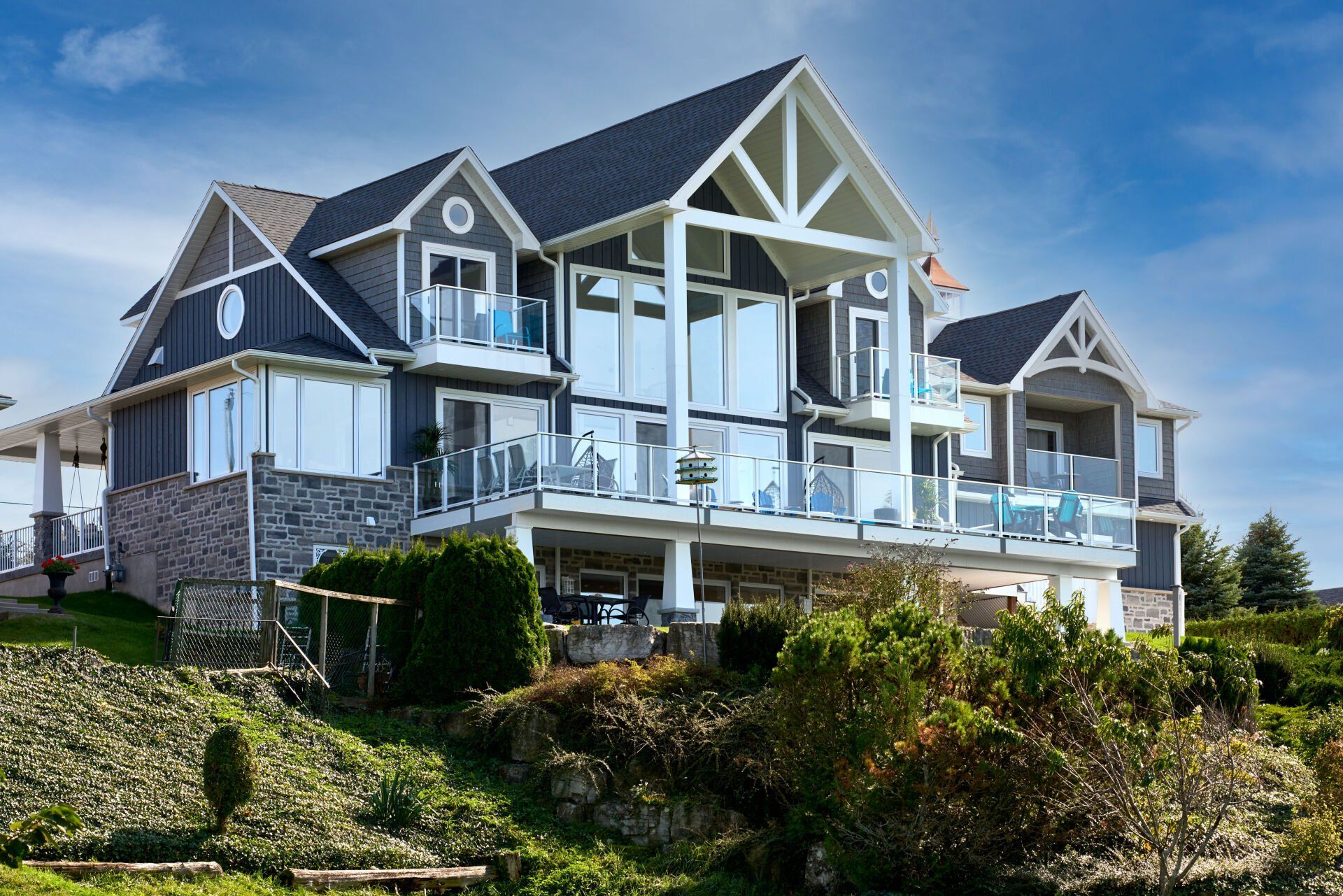 A large house with a lot of windows is sitting on top of a hill.