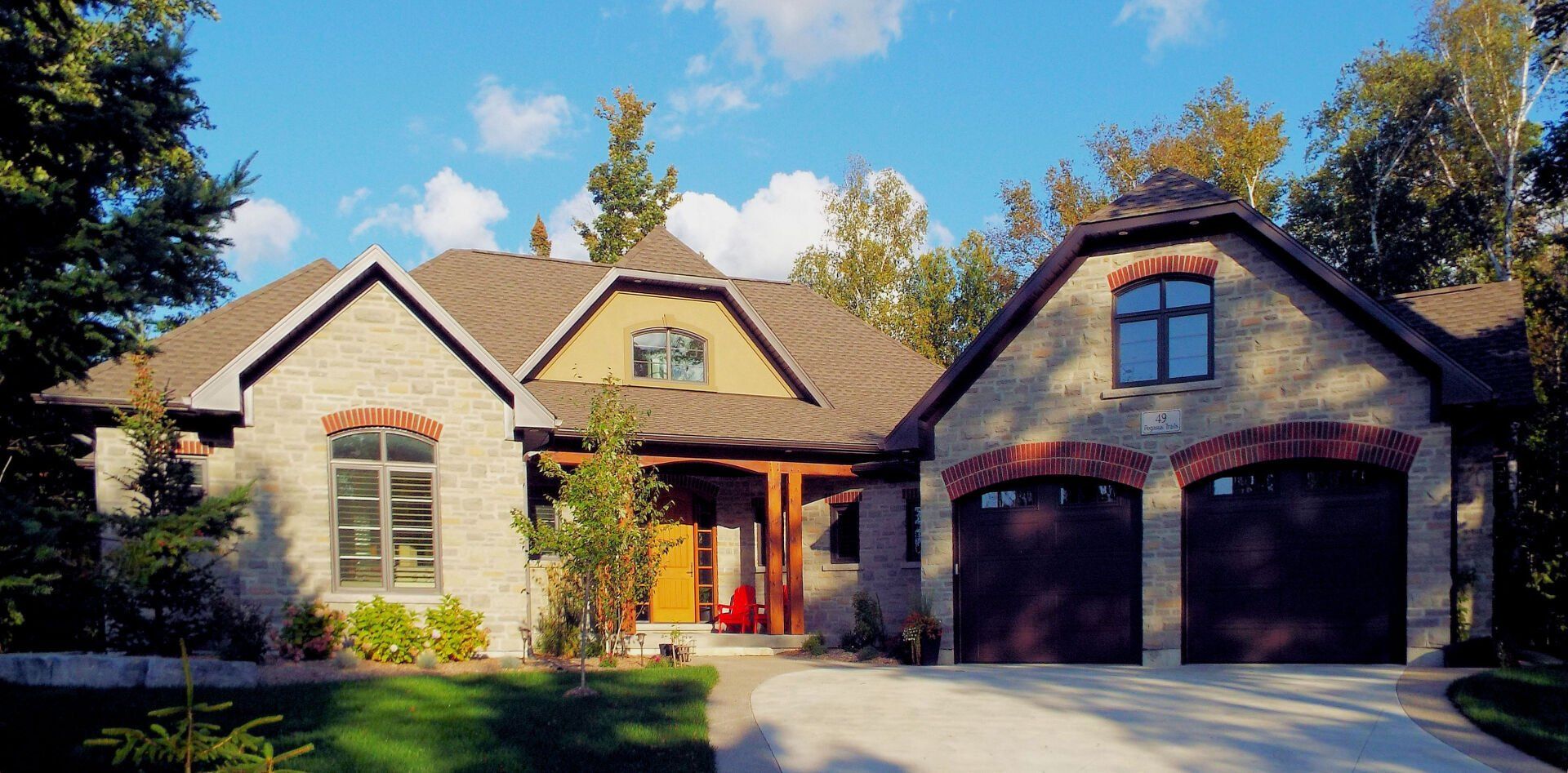 A large house with two garages and a driveway in front of it.