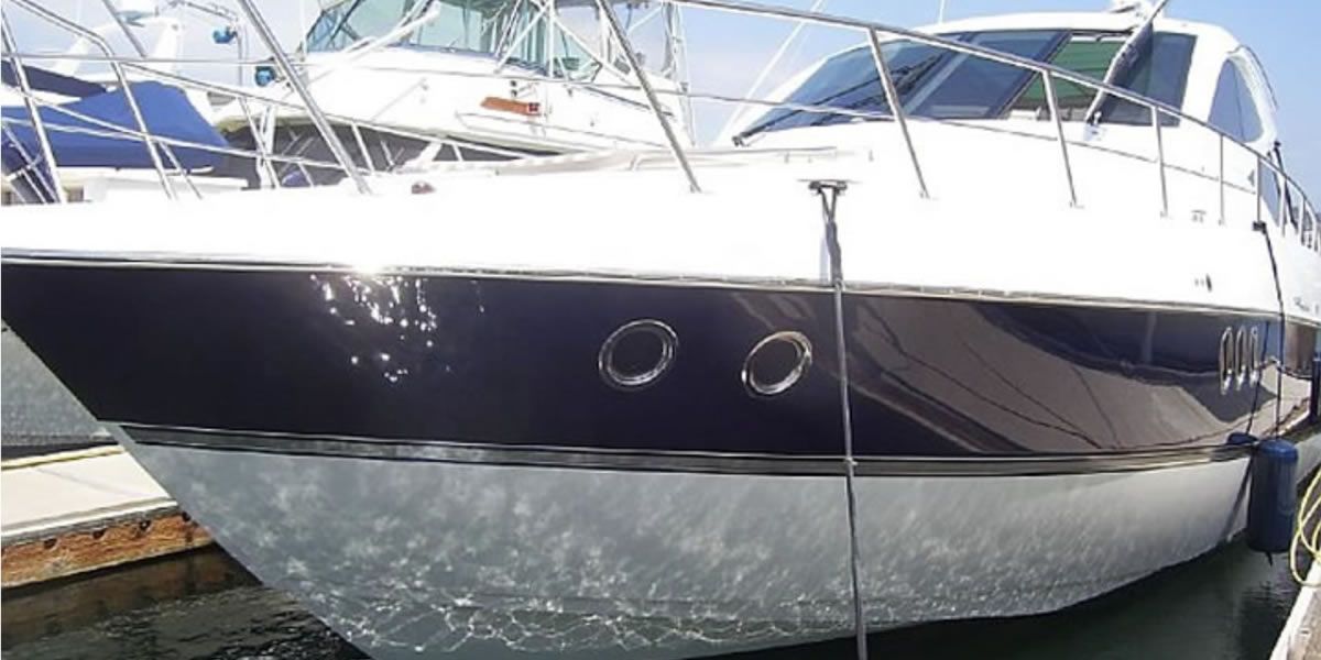 A black and white boat is docked in a marina.