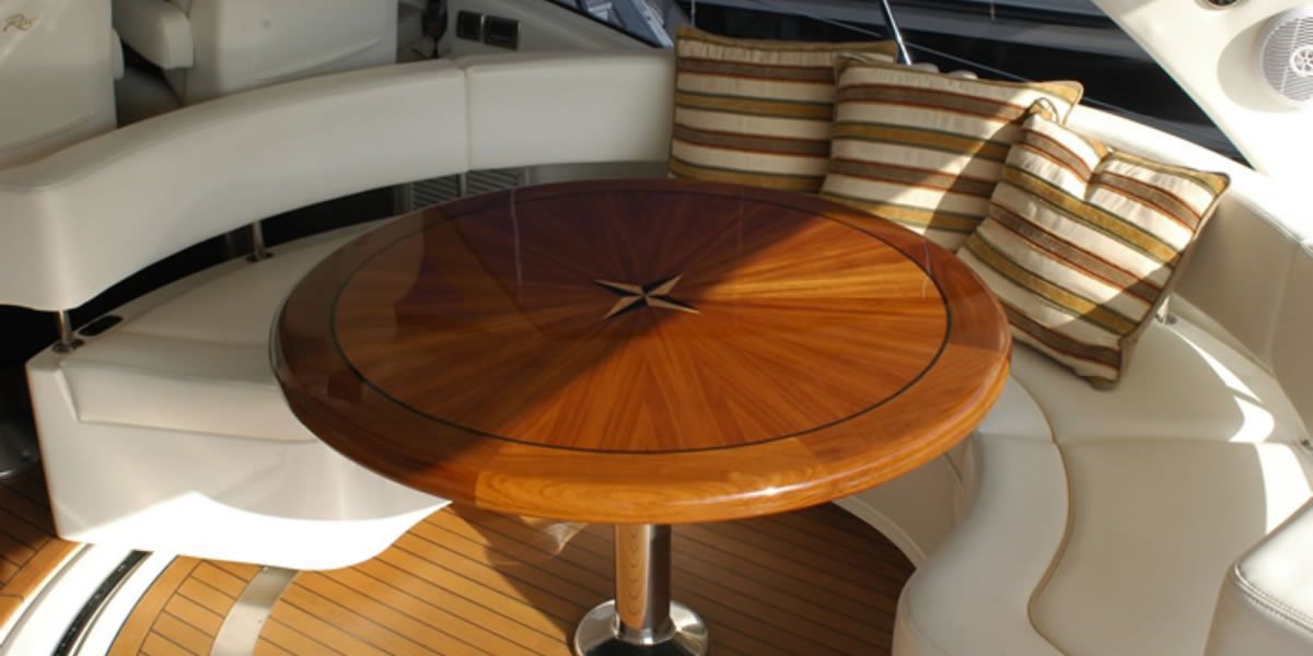 A round wooden table is sitting in the middle of a boat.