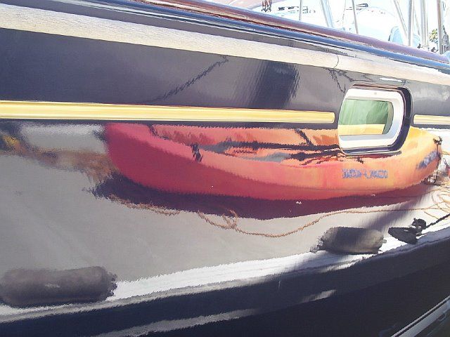 A red kayak is sitting on the side of a boat