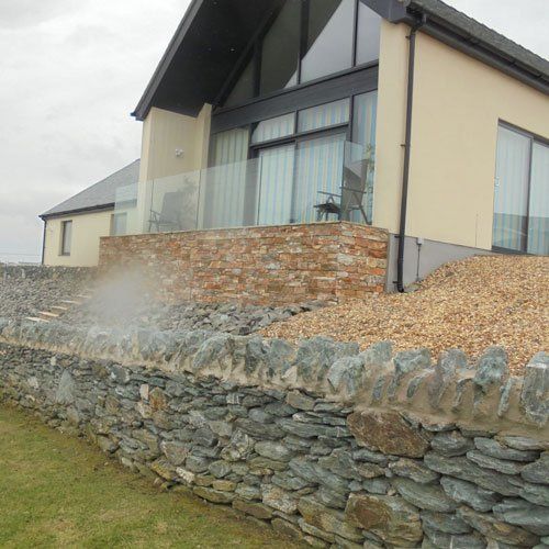 modern home with dry stone wall