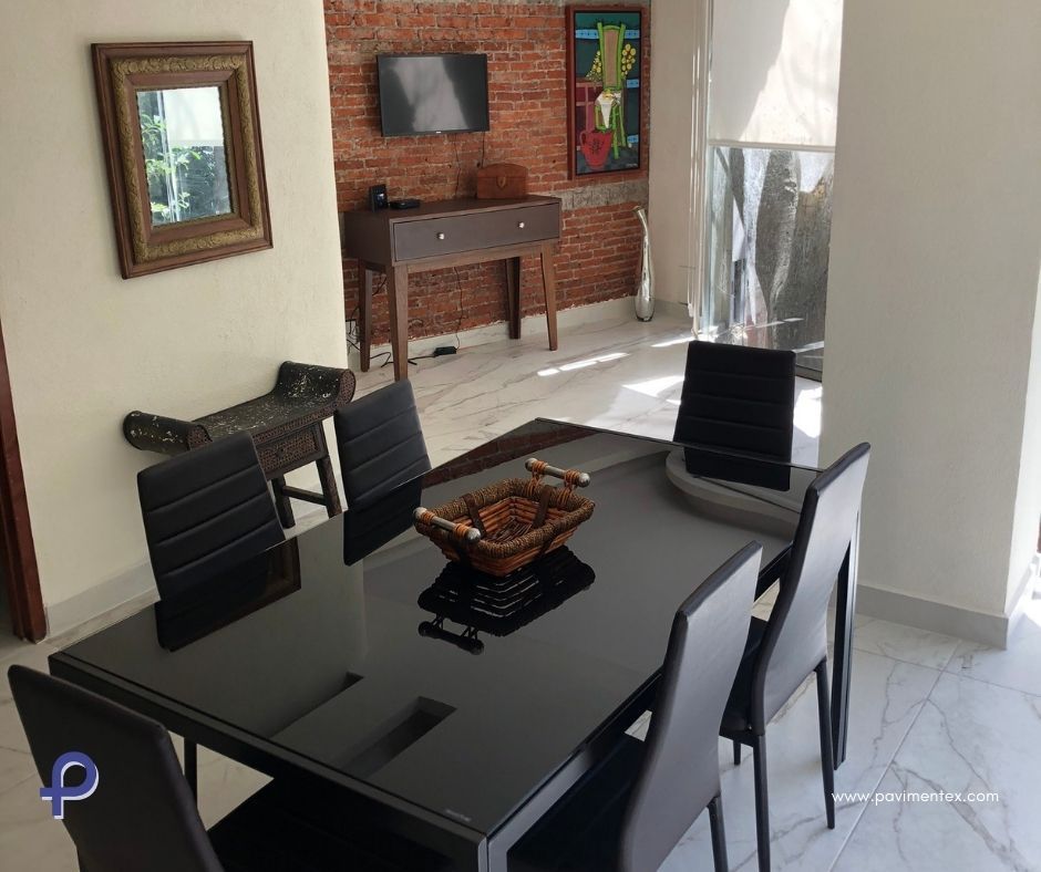 Un comedor con mesa y sillas negras.