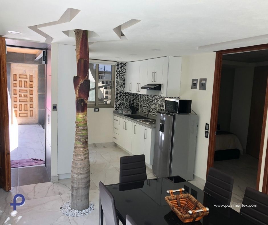 Una cocina con mesa y sillas de comedor y refrigerador de acero inoxidable.