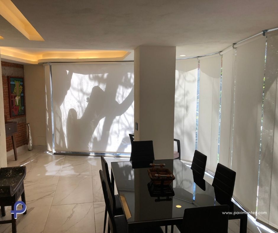 Un comedor con mesa, sillas y pantalla de proyección.