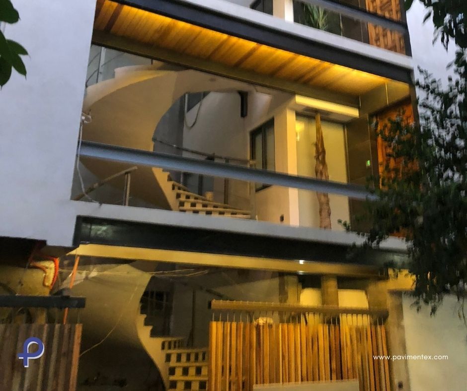 Una casa con escalera de caracol y valla de madera.