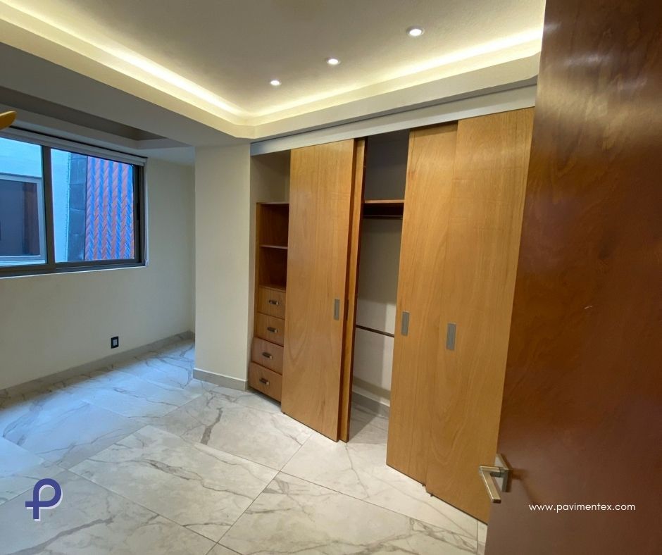 Un dormitorio con puertas correderas de madera y ventana.