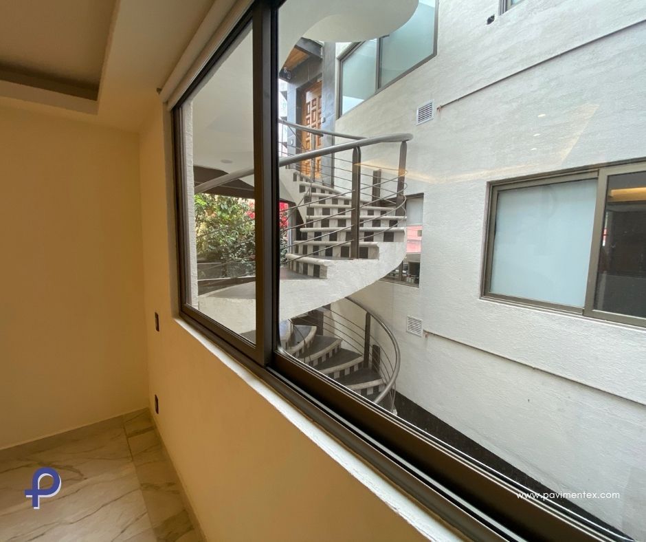 Una escalera de caracol es visible a través de una ventana en un edificio.