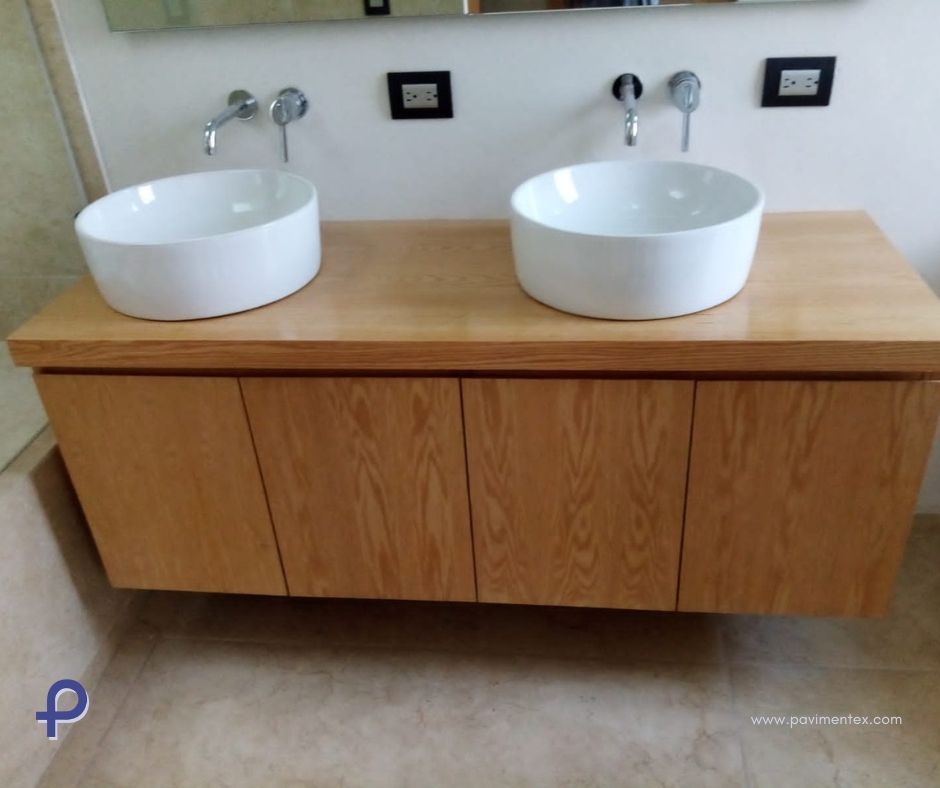 Tocador flotante de madera con dos lavabos blancos y grifería cromada.