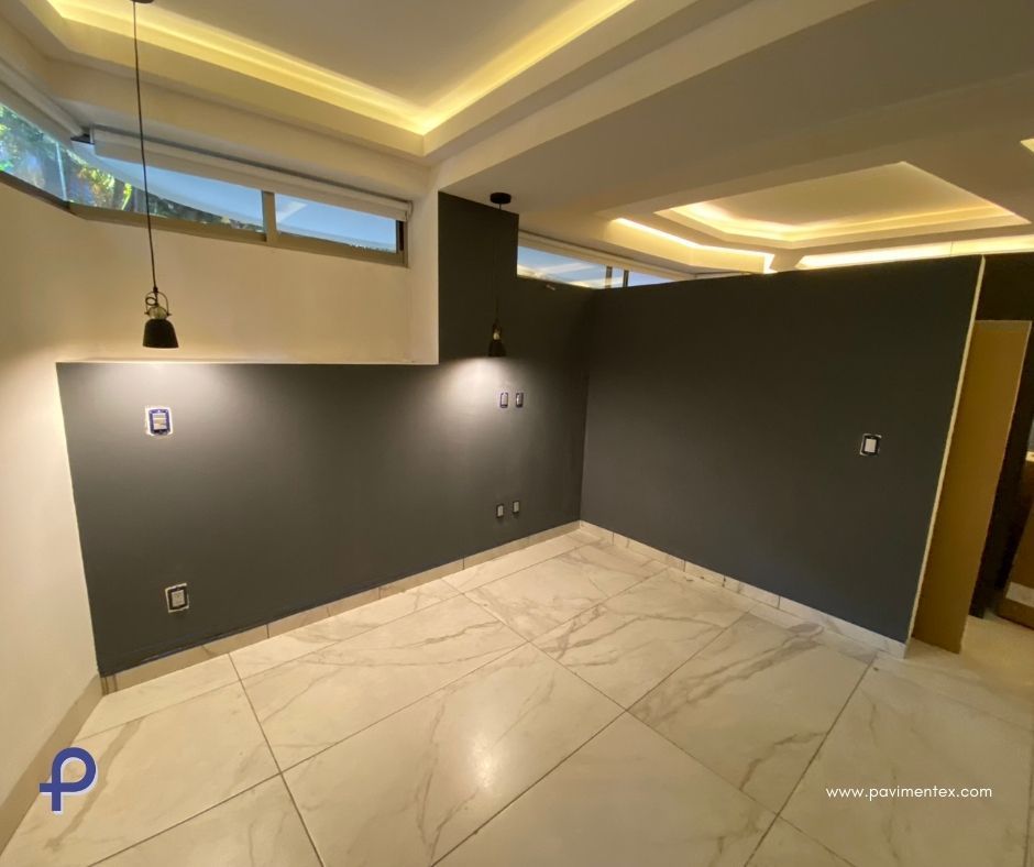 Una habitación vacía con suelo de mármol y lámpara de techo.