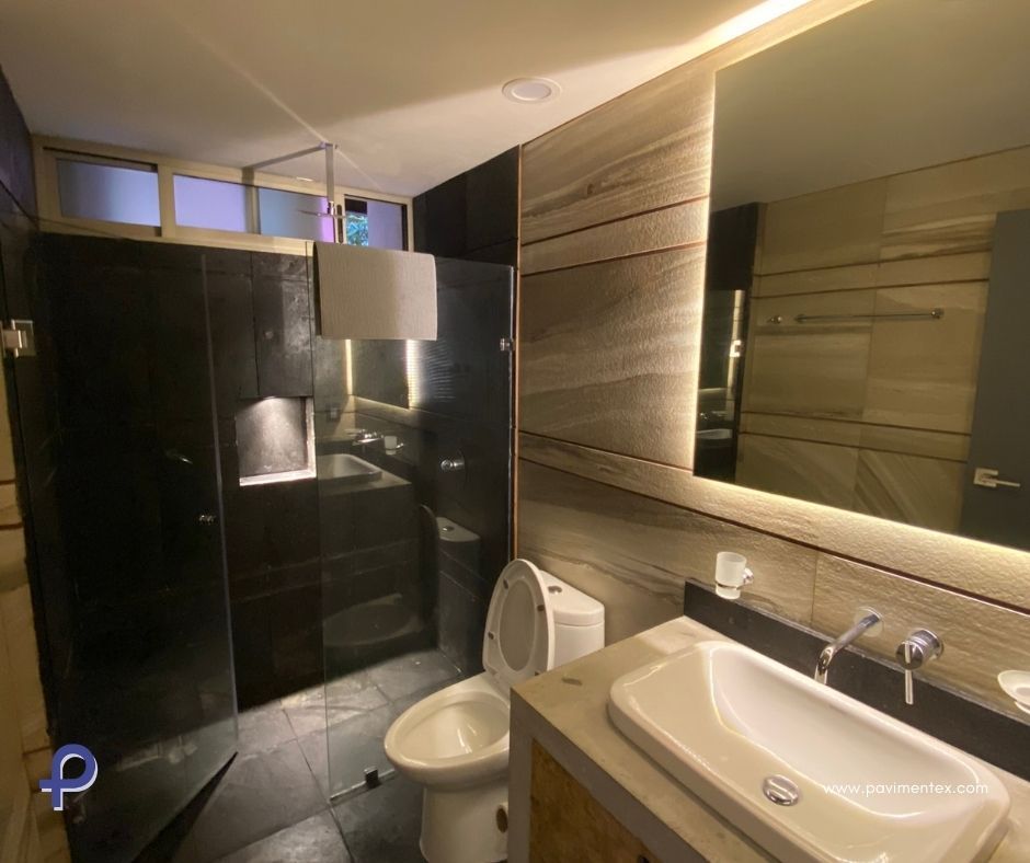 Un cuarto de baño con inodoro, lavabo y espejo.