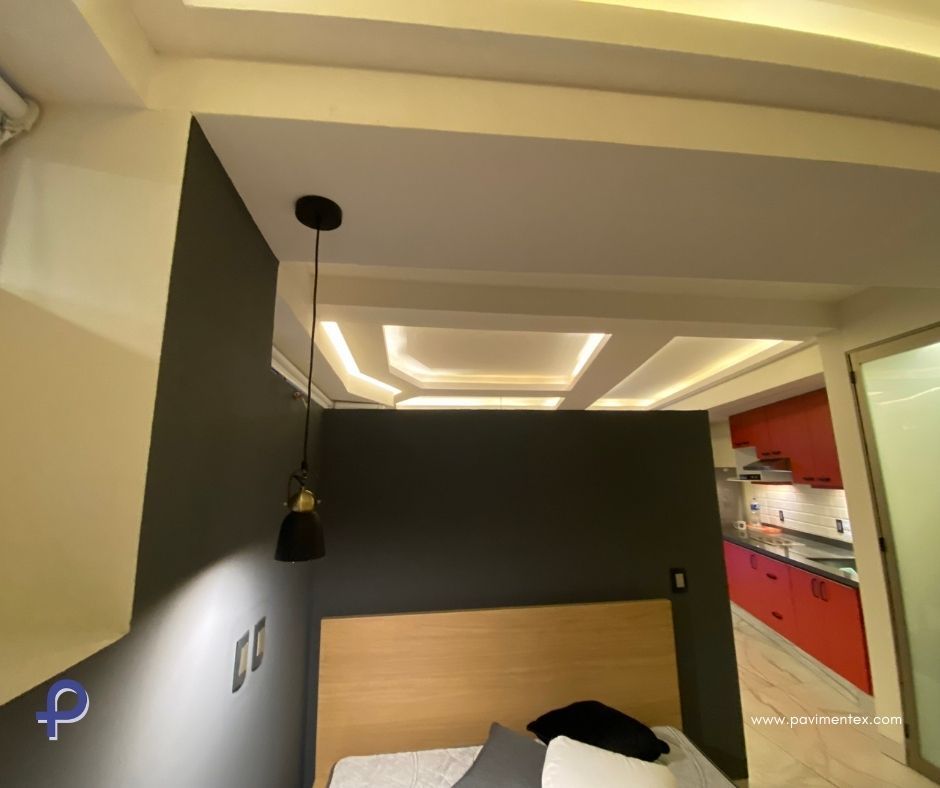 Un dormitorio con una cama y una lámpara colgada del techo.