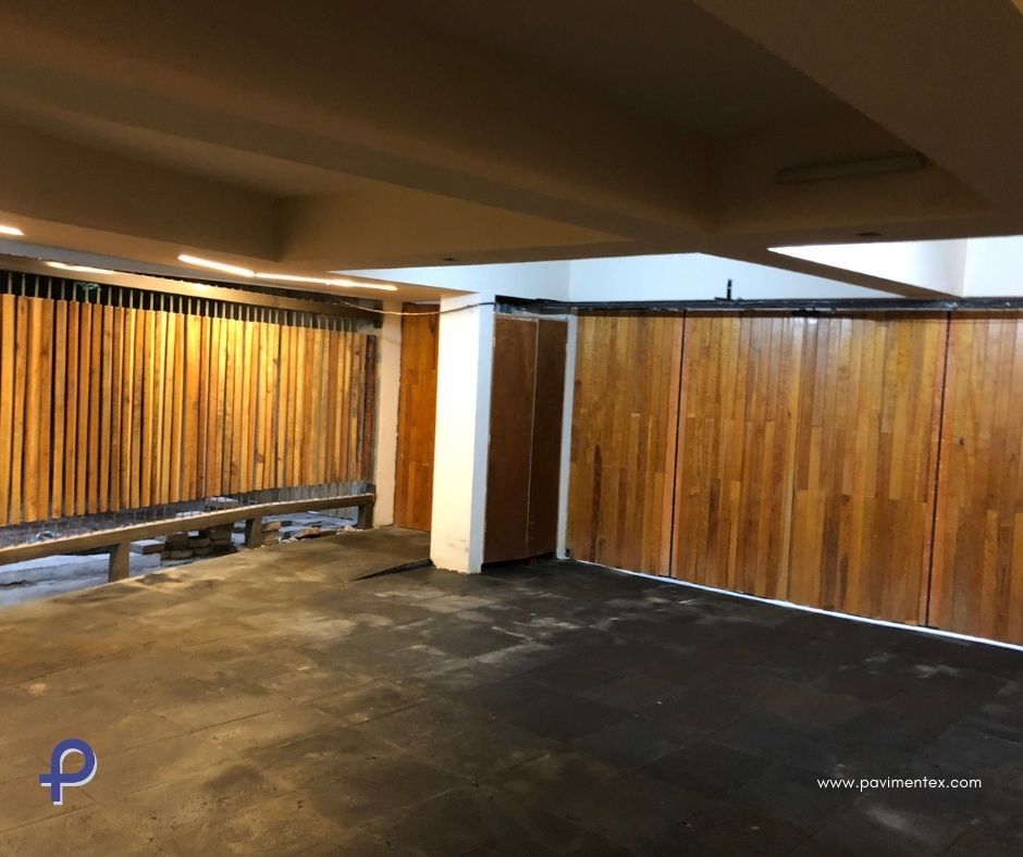 Un garaje con pared de madera y suelo negro.
