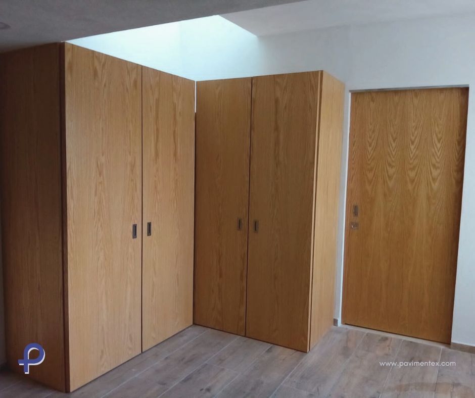 Armarios de madera y puerta a juego en una habitación con suelo de madera clara.