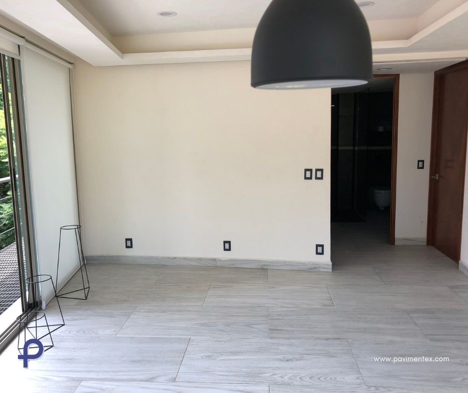 Una habitación vacía con paredes blancas y una lámpara colgante negra.