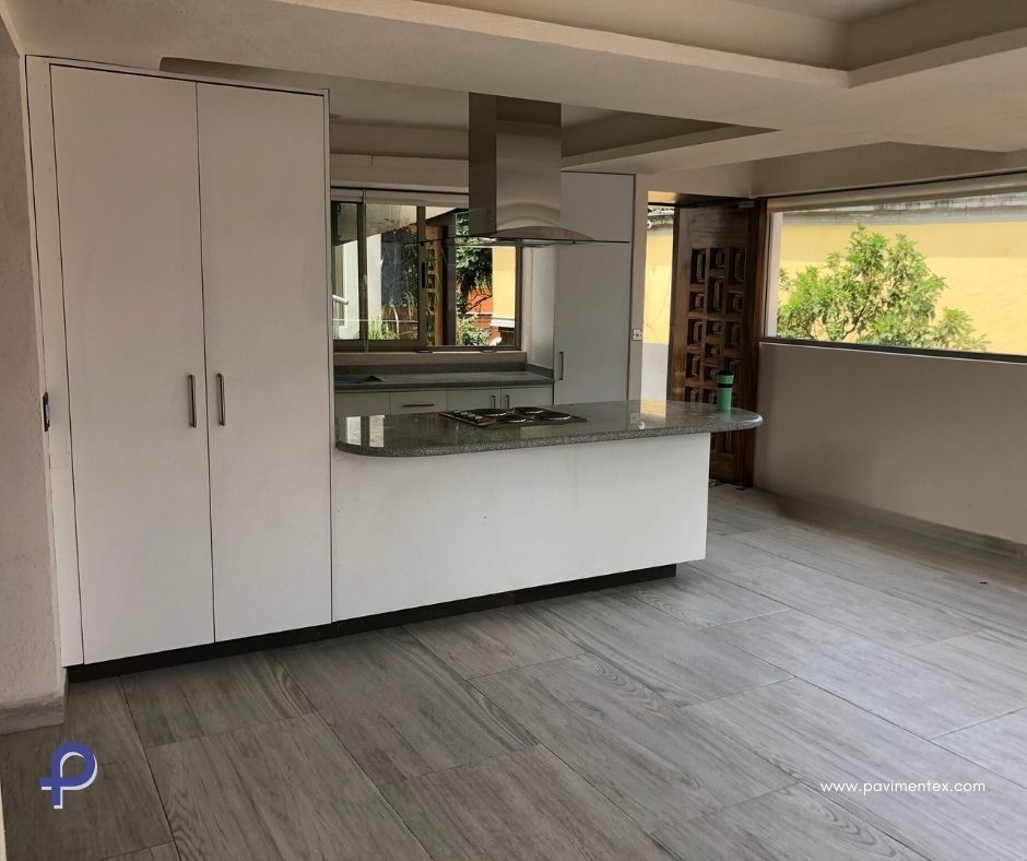 Una cocina vacía con armarios blancos y horno.