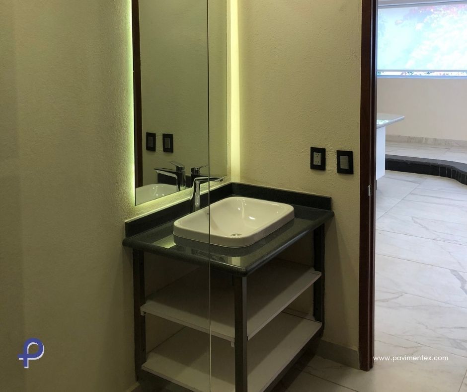 Un baño con lavabo, espejo y estanterías.