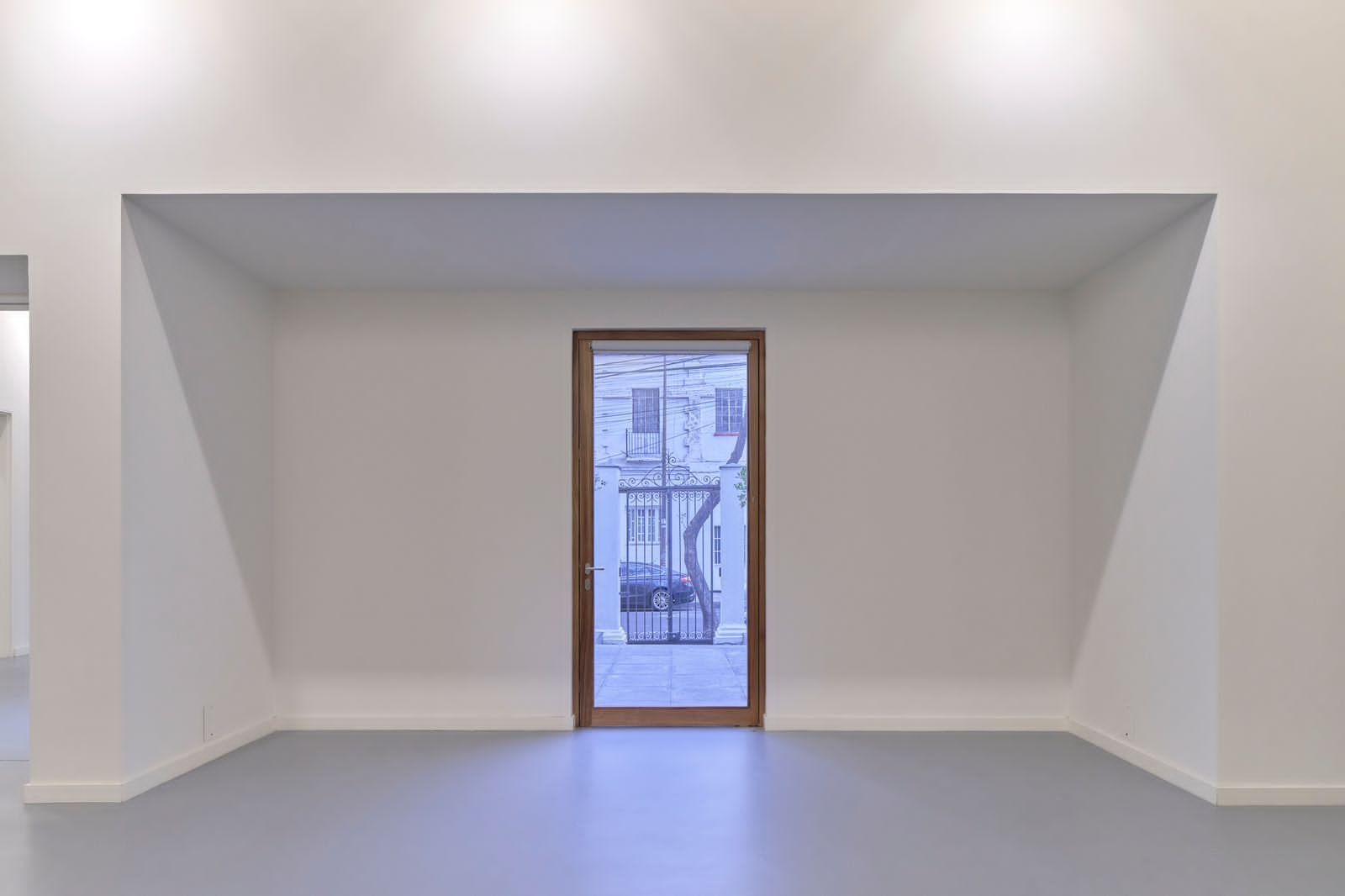 Una habitación vacía con una ventana y una puerta.