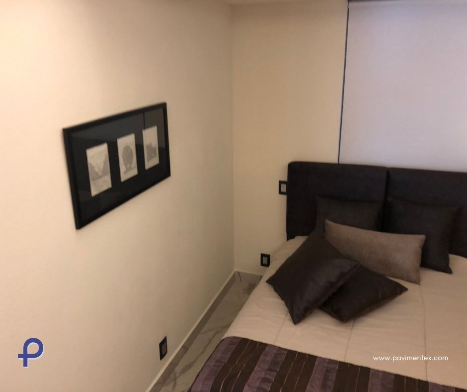 Un dormitorio con una cama y un cuadro en la pared.