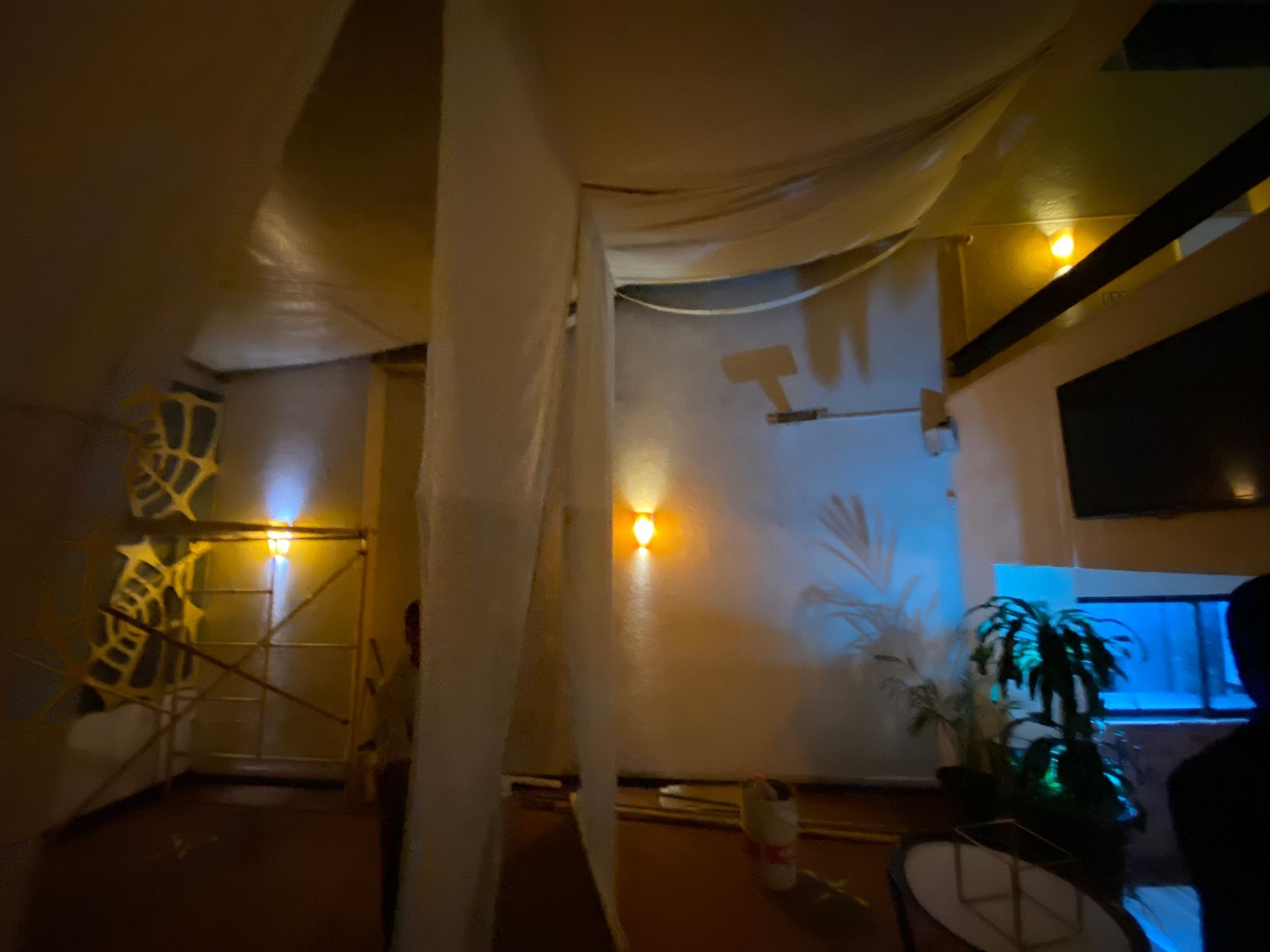 Una habitación oscura con una cortina blanca colgando del techo.