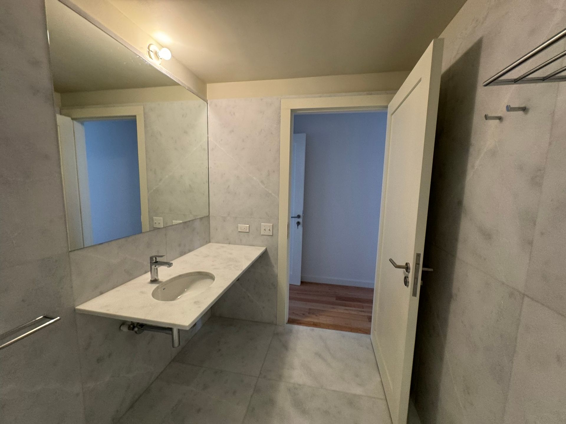 pavimentex construcción de un baño con instalación de lavabo, espejo y puerta.