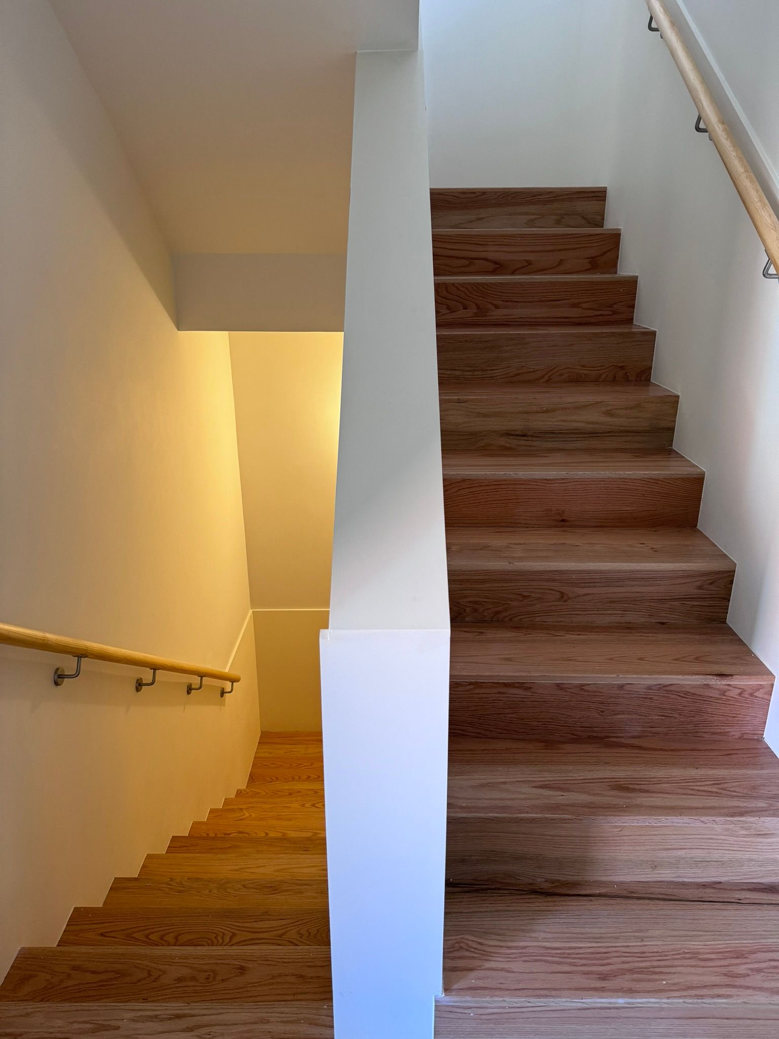 pavimentex una escalera con peldaños de madera y una pared blanca.