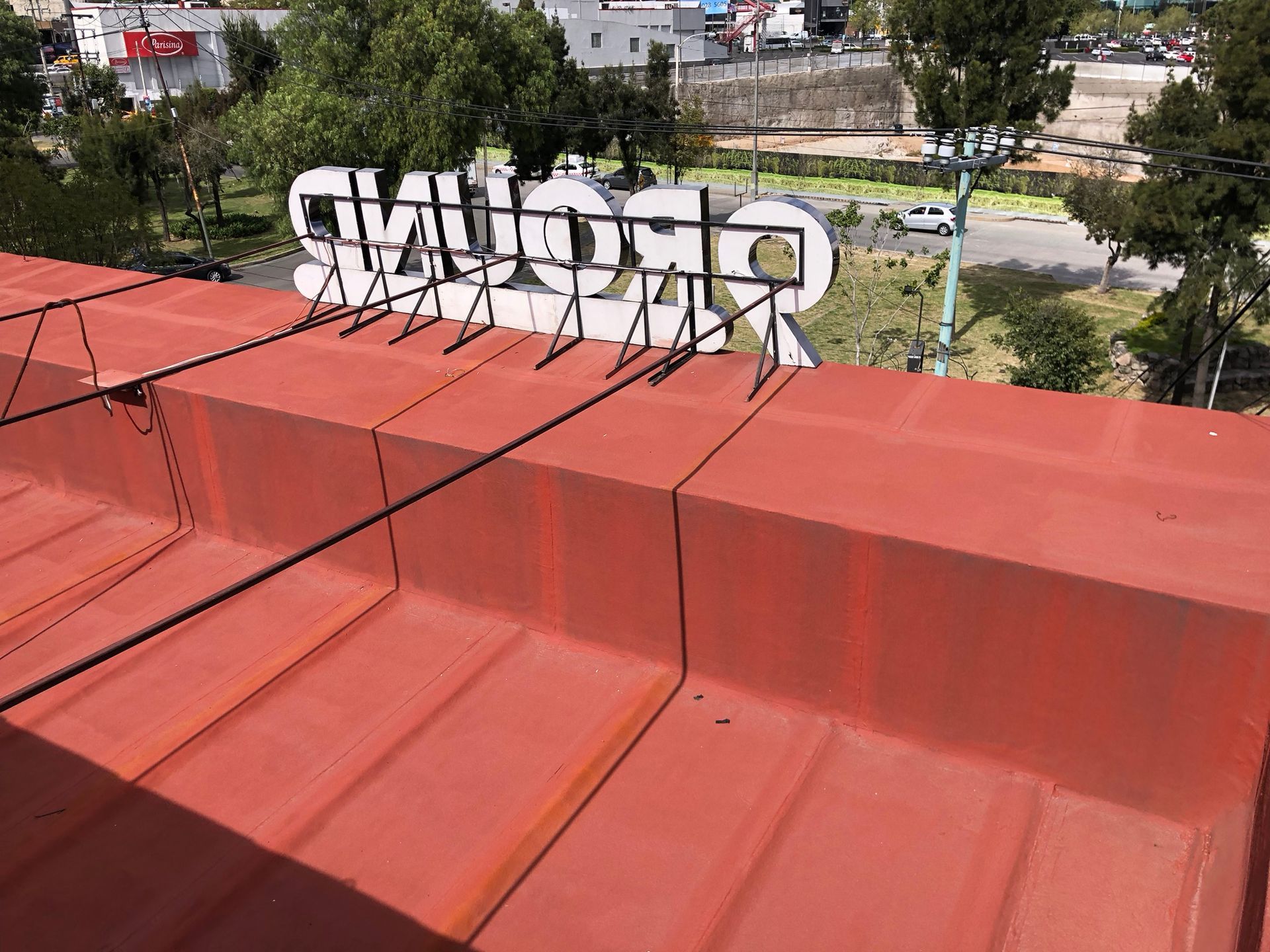 Tejado rojo con pinchos metálicos y la palabra 