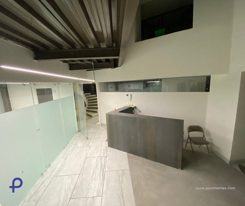 Espacio de oficina moderno con mostrador de recepción, vidrio esmerilado y escalera de caracol.