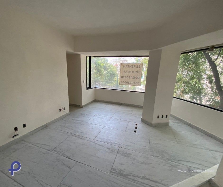 Habitación vacía con piso de baldosas de color gris claro, ventanas grandes y paredes de colores neutros.