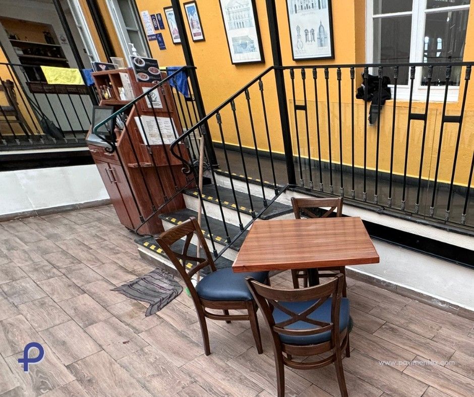 Una mesa y sillas de madera en una habitación con escaleras.