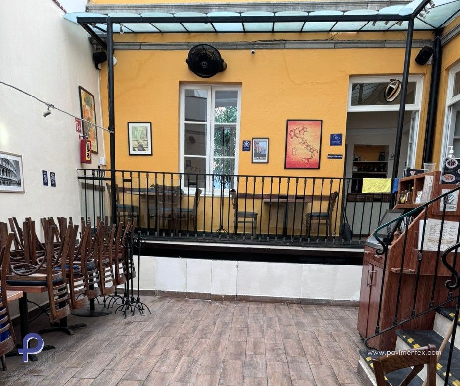 Un restaurante con mesas y sillas y un balcón.