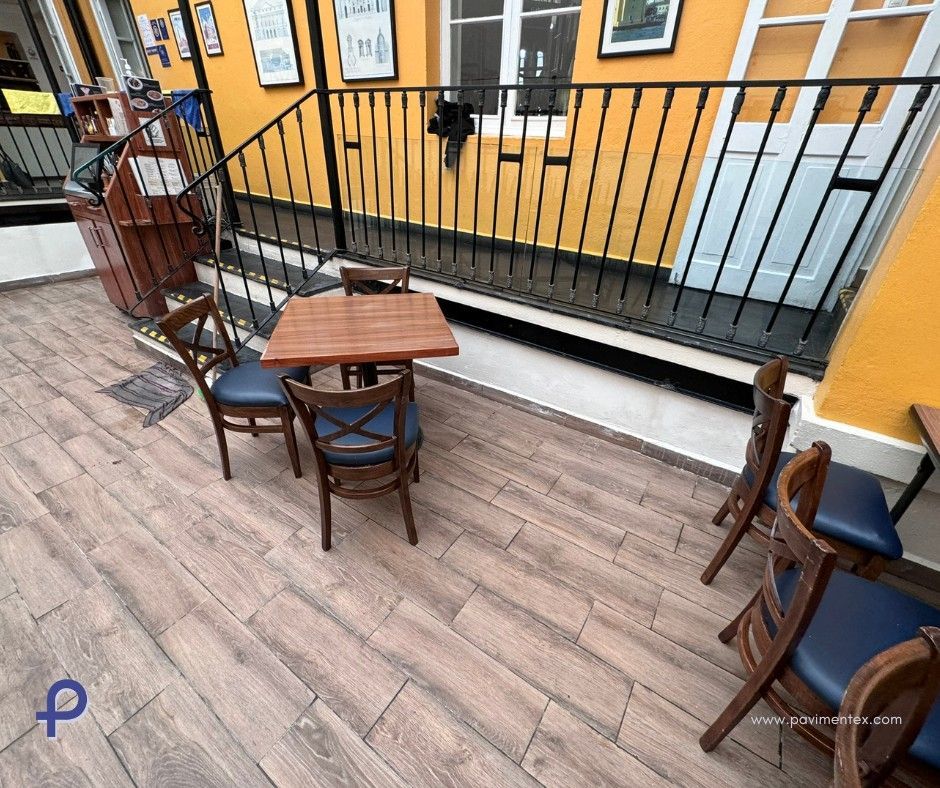 Un patio con mesas y sillas frente a un edificio.