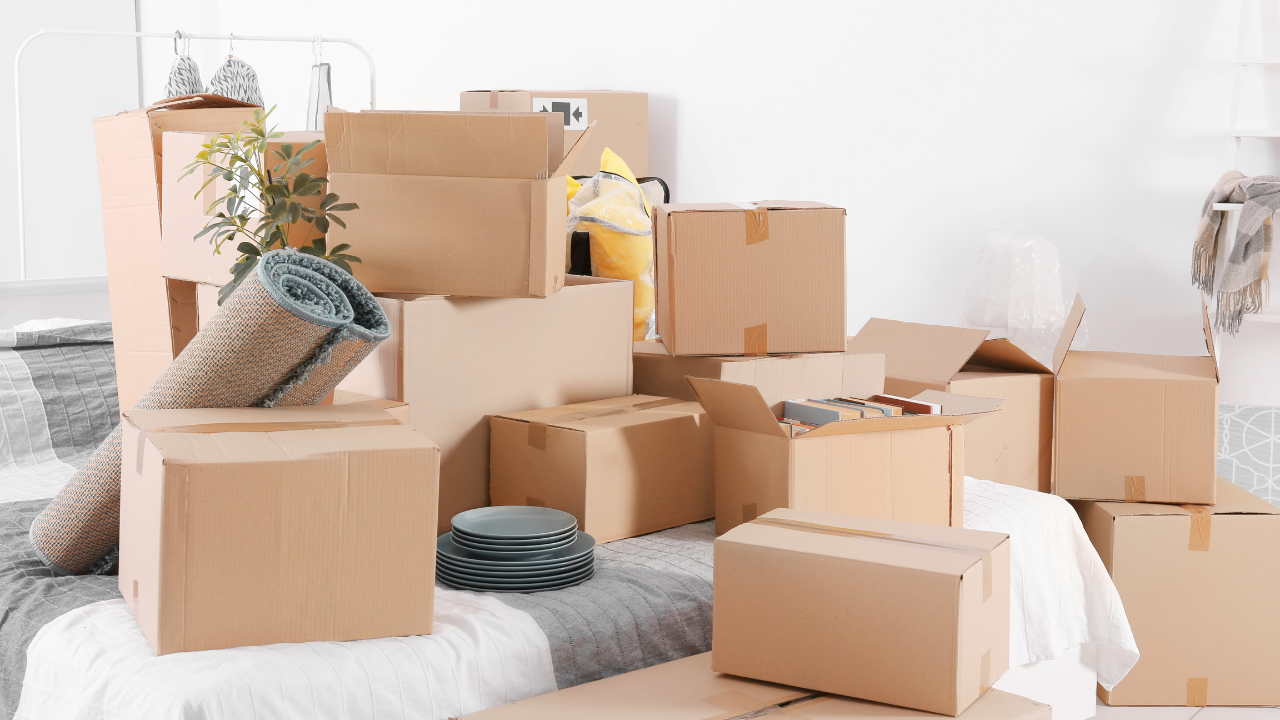 Boxes stacked on a bed; moving, packing items for transport.