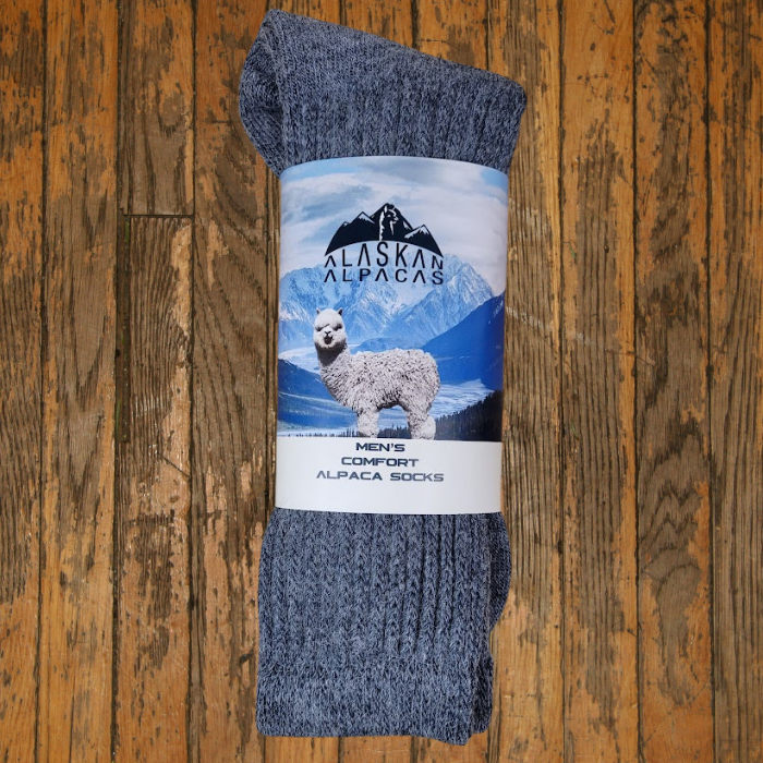 Pair of gray alpaca socks with a label featuring an alpaca and mountain scene.