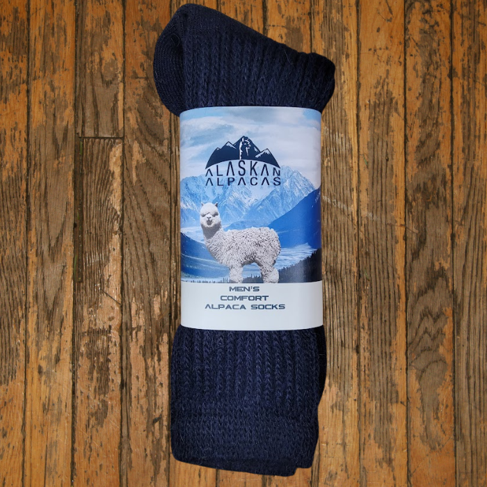 Pair of rolled-up navy alpaca wool socks with a label featuring an alpaca and mountain scene.