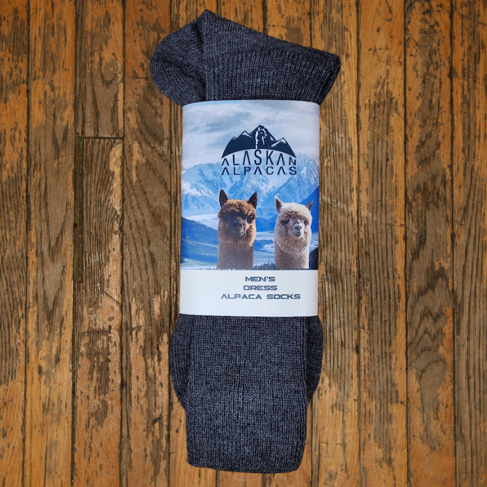 Pair of dark gray alpaca socks with label featuring alpacas and mountains.