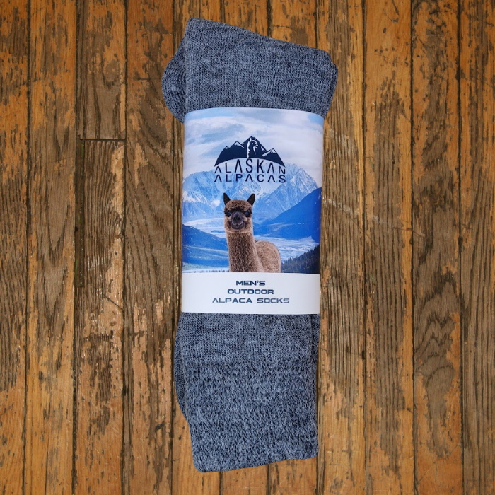 Gray alpaca socks with label featuring an alpaca and mountains.