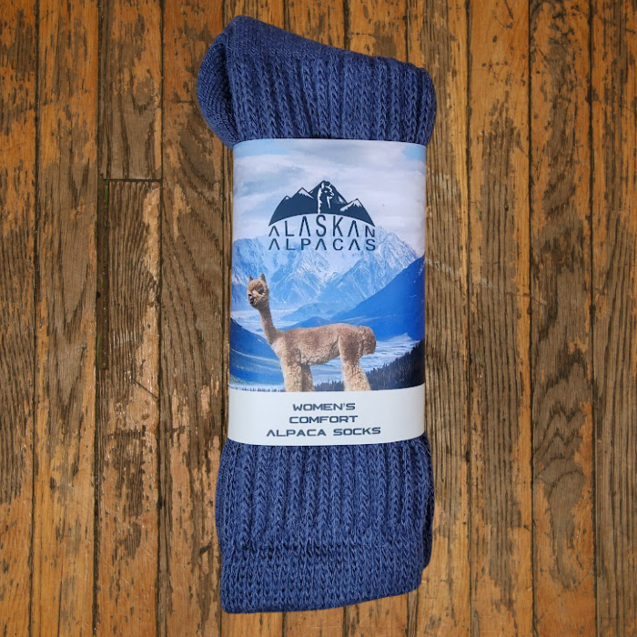 Blue alpaca socks with a label showing an alpaca in a mountain scene.
