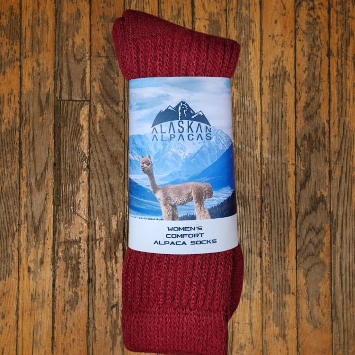 Red alpaca socks with a label that features an alpaca and mountains.
